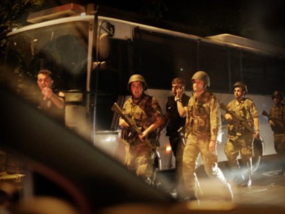 Turkish security officers detain Turkish police officers (in black) on July 15, 2016 in Istanbul, during a security shutdown of the Bosphorus Bridge. The Turkish military on July 15 said that it had assumed power over Turkey, in what the prime minister has termed an illegal act. "The power in the country has been seized in its entirety," said a military statement read on NTV television, without giving further details. The military's website was not immediately accessible. / AFP PHOTO / BULENT KILIC